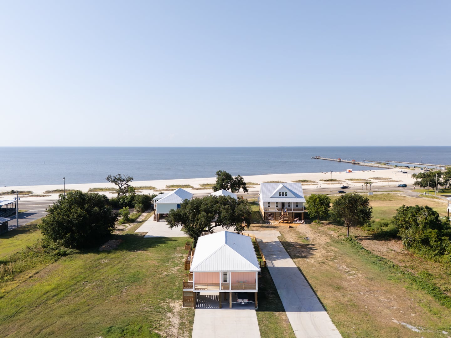 Aerial view of the home and nearby Gulf beach across the coastal road